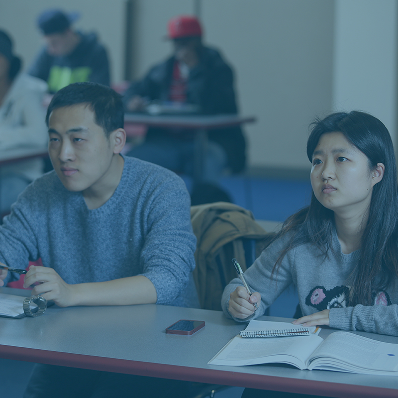 Two students at a table listening